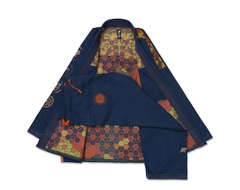 Puede incluir: Un gi de artes marciales azul marino con un forro interior en contraste que presenta un patrón geométrico repetitivo en tonos naranja, verde y marrón. La chaqueta tiene mangas largas y el pantalón incluye un cordón naranja en la cintura.