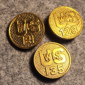 May include: Three gold-colored metal buttons with the text "WIS" and a number on each. The numbers are 121, 128, and 135.