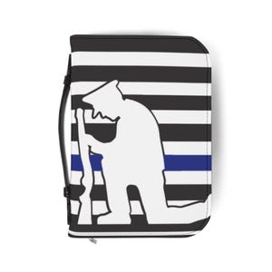 May include: A rectangular zippered case with a black handle on the left side. The surface features a pattern of horizontal black and white stripes with a single thin blue horizontal line across the center. A white silhouette of a kneeling soldier.