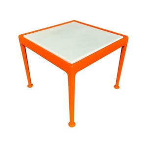 May include: A square side table with a white top and bright orange legs. The table is approximately 18 inches tall and 18 inches wide, with a modern, minimalist design. The legs have rounded feet.