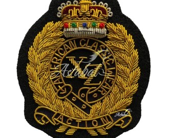 May include: Embroidered patch with a black background, featuring a gold crown and laurel wreath design. The patch includes the text "AMERICAN CLASSIC WEAR ACTION" in gold thread, with additional details in red, green, and blue.