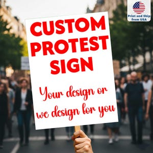 May include: A white protest sign with the words "CUSTOM PROTEST SIGN" in large red letters. Below, in a cursive font, it reads "Your design or we design for you." The sign is held up in a crowd.
