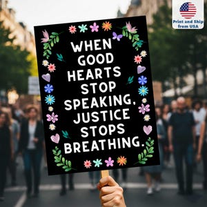 May include: A black sign with the text "WHEN GOOD HEARTS STOP SPEAKING, JUSTICE STOPS BREATHING." is held up in a crowd. The sign is decorated with colorful flowers and leaves. The upper right corner has a small American flag.