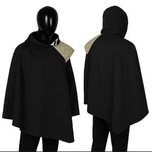 May include: A black hooded poncho featuring an asymmetrical hem and a beige quilted shoulder panel. The garment is displayed on a mannequin from both the front and back views, showcasing the solid black fabric and the textured light-coloured accent.