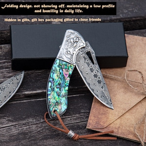 Może przedstawiać: Składany nóż z wzorzystym ostrzem i rękojeścią inkrustowaną iryzującą muszlą abalonu. Nóż jest częściowo otwarty, odsłaniając wzór ostrza. Obraz zawiera tekst: „Składana konstrukcja, nie obnosząc się, zachowując niski profil i pokorę w życiu codziennym.”