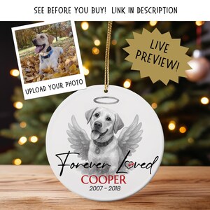 May include: A white ceramic ornament featuring a Labrador Retriever with angel wings and a halo. The text "Forever Loved" and the name "COOPER" with dates 2007-2018 are below the dog. A photo of the dog is in the upper left. Text reads "SEE BEFORE YOU BUY! LINK IN DESCRIPTION" and "LIVE PREVIEW!"