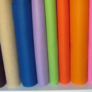 May include: A collection of rolled felt fabric in various colours, including beige, blue, purple, green, orange, and pink.