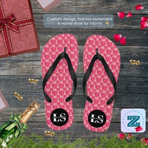 May include: A pair of pink flip-flops with a heart pattern and black straps. The flip-flops have a black circle with the letters "LS" and the words "LUNA STEWART". The text "Custom design, fashion statement & vacay style for moms" is also visible.