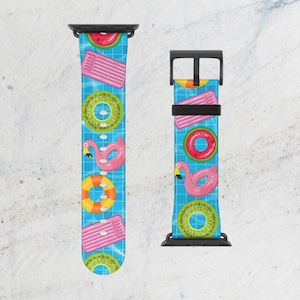 May include: A watch band with a blue background featuring a pattern of summer pool floats. The floats include pink flamingo, watermelon, kiwi, and pink pool floats. The watch band has a black clasp.