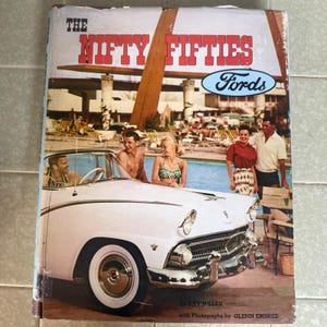 May include: A hardcover book titled The Nifty Fifties Fords by Ray Miller with photographs by Glenn Embree. The cover features a white vintage Ford car in the foreground and a swimming pool scene with people in the background.