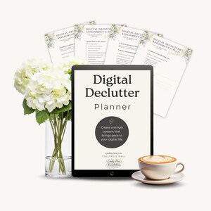 May include: A digital declutter planner on a tablet with the title "Digital Declutter Planner". The tablet is next to a bouquet of white flowers in a glass vase and a cup of coffee. Several assessment and plan sheets are behind the tablet.