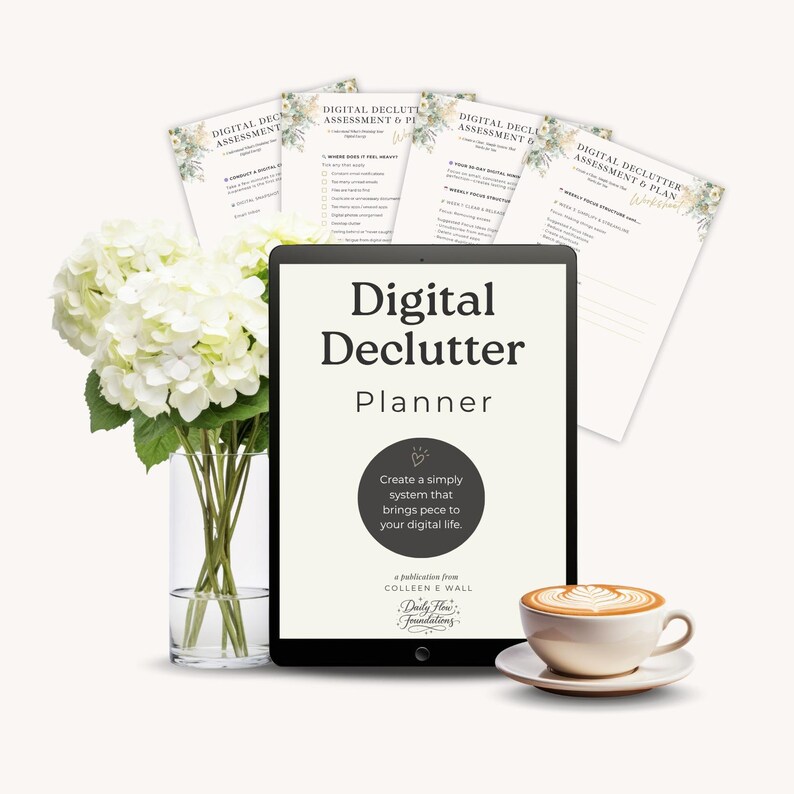 May include: A digital declutter planner on a tablet with the title "Digital Declutter Planner". The tablet is next to a bouquet of white flowers in a glass vase and a cup of coffee. Several assessment and plan sheets are behind the tablet.