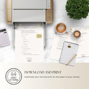May include: A printer is shown with a printed worksheet titled "Digital Declutter Assessment & Plan." Other items include a calculator, a cup of coffee, a candle, a notepad, and a pen. The image also includes a "Print at Home" graphic.