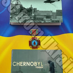 Könnte beinhalten: Zwei Bücher mit den Titeln "ЧОРНОБИЛЬ 1986" und "CHERNOBYL TODAY" werden gezeigt. Das erste Buch zeigt einen Hubschrauber über einem beschädigten Gebäude. Das zweite Buch zeigt eine Person in Schutzkleidung. Zwischen den Büchern befindet sich eine Medaille.
