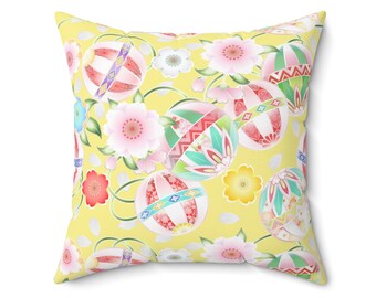 Könnte beinhalten: Quadratisches Kissen mit leuchtend gelbem Hintergrund. Es zeigt ein sich wiederholendes Muster aus stilisierten floralen und geometrischen Designs in Rosa, Grün, Rot und Weiß. Das Design umfasst Blumen und dekorative Kugelformen.