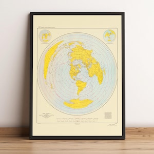 May include: Framed vintage world map print. The map features a circular projection of the world with yellow landmasses and blue oceans. The map is set against a cream-colored background and is framed in black. The title "THE WORLD" is visible at the bottom.