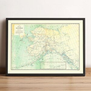 May include: A framed vintage map of Alaska, showing the state's geography in detail. The map uses green, yellow, and beige tones, with text reading "Map of Alaska". It is presented within a black frame.