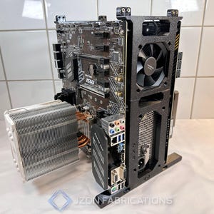 Può includere: Un case per computer nero con una scheda madre, un dissipatore CPU e una ventola. Il case ha un design rettangolare con una ventola nera e un dissipatore CPU argentato. La scheda madre è nera.
