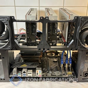 May include: A black computer rig featuring two large fans, a motherboard, and multiple graphics cards. The rig has the text "IZON FABRICATIONS" at the base. The fans display the Arctic logo.