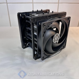 Puede incluir: Un enfriador de CPU de computadora negro con un ventilador grande y aletas de disipador de calor. El ventilador tiene un logotipo central y aspas curvas. El enfriador está diseñado para disipar el calor.