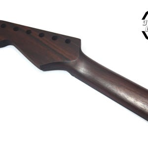 May include: A dark brown guitar neck with six tuning peg holes. The neck is made of wood and has a smooth finish. The headstock is shaped in a classic design. The logo "3 Hit Guitars" is in the upper right corner.