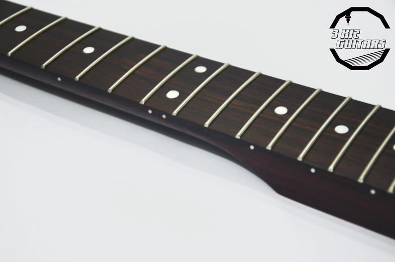 May include: Close-up of a guitar fretboard with silver frets and white dot inlays. The dark wood has a rich grain pattern. The logo "3 KHz GUITARS" is in the upper right corner. This is a guitar part.