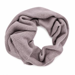 May include: A mauve-coloured infinity scarf featuring a fine-knit texture. The circular garment is arranged in a loose, folded loop, showcasing the consistent ribbed pattern of the fabric throughout the entire surface of the soft, knitted accessory.