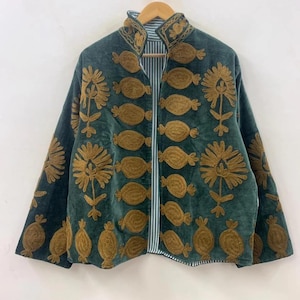 May include: A dark teal jacket with gold-colored embroidered floral and oval designs. The jacket has a mandarin collar and a striped lining. The jacket is hanging on a wooden hanger against a white background.