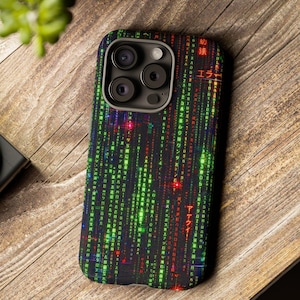 以下が含まれることがあります： 緑、赤、白のデジタルレインパターンが特徴の黒いスマートフォンケース。ケースにはカメラの切り抜きがあります。デザインはコンピュータコードまたはマトリックスに似ています。