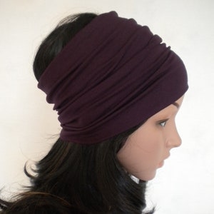 Peut inclure: Un bandeau extensible de couleur pourpre, en tissu doux. Le bandeau est porté sur la tête et plié pour créer une bande épaisse.