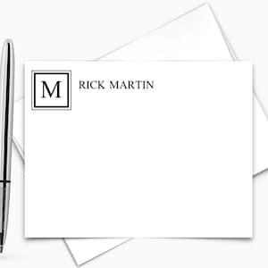 May include: A white card with a black border around the letter "M" and the text "RICK MARTIN" printed in black.