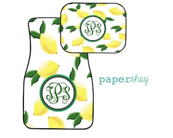May include: Two car floor mats with a lemon print and a monogram in a circle. The monogram is the letters "PS" in green. The mats are white with yellow lemons and green leaves.