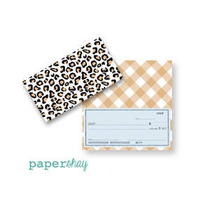 May include: A check with a light blue background and a gold gingham pattern. The checkbook cover has a leopard print design. The text "papershay" is in the bottom left corner.