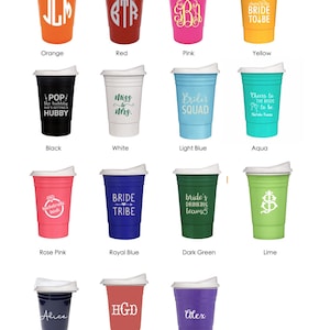 Op de afbeelding: Een verzameling kleurrijke plastic bekers met witte deksels, elk in een andere kleur, waaronder oranje, rood, roze, geel, zwart, wit, lichtblauw, aqua, roze, koningsblauw, donkergroen, limoen, marine, koraal en paars. Elke beker heeft een uniek ontwerp of tekst.