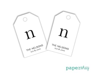 May include: Two white gift tags with a black letter "n" and the text "The Nelsons Sue & John" printed on them.