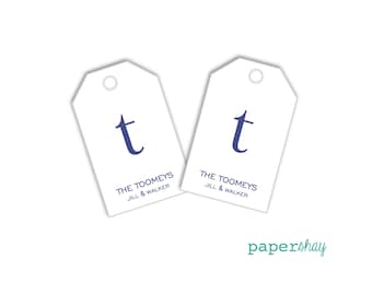 May include: Two white gift tags with a navy blue letter "t" and the text "THE TOOMEYS JILL & WALKER". The tags have a small hole at the top for stringing. The word "papershay" is written in teal script at the bottom right.