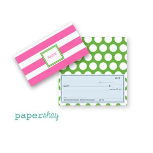 May include: Pink and white striped checkbook cover with the name "Anne" in a green box. The checkbook cover is paired with a green and white polka dot checkbook cover.