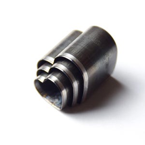 Puede incluir: Un juego de cuatro punzones metálicos en forma de corazón, anidados entre sí. Los punzones están hechos de un metal oscuro de estilo industrial con un borde plateado. Las formas de corazón son visibles en el punzón inferior.