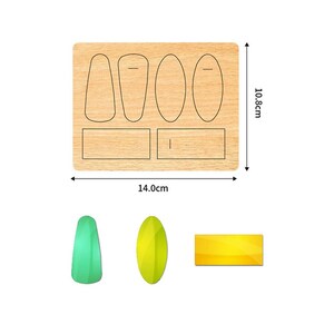 May include: A wooden die-cut template with various shapes, including ovals and rectangles, measuring 14.0cm wide and 10.8cm tall. Below are examples of the shapes in green, yellow, and gold.