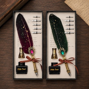 May include: Two rectangular gift boxes containing quill pens with gold-flecked feathers in deep burgundy and dark green. Each set includes a metal pen holder, five interchangeable nibs, and a black ink bottle labeled Magic Power.
