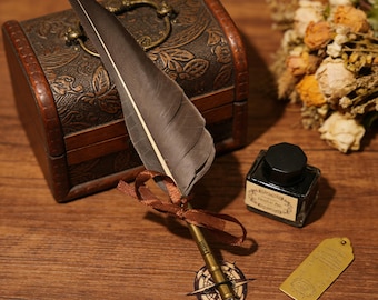 Puede incluir: Una pluma de estilo vintage con una pluma marrón y una punta de color bronce, atada con una cinta marrón. La pluma descansa sobre una superficie de madera junto a un pequeño cofre de madera, un tintero y una etiqueta de latón. La escena evoca la escritura.