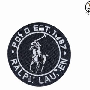 Peut inclure: Écusson rond brodé noir et blanc avec le logo Polo Ralph Lauren. Le patch présente les mots "POLO EST. 1967 RALPH LAUREN" autour d'un joueur de polo à cheval. Un design classique pour les vêtements.