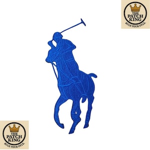 May include: A blue embroidered patch depicting a polo player on horseback. The patch is intricately designed and set against a white backdrop. The patch includes the text "THE PATCH KING" and "RULE YOUR STYLE".