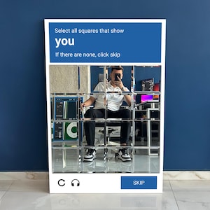 K&ouml;nnte beinhalten: Ein wei&szlig; gerahmtes Kunstwerk mit einem blauen oberen Bereich, der den Text "W&auml;hle alle Quadrate aus, die dich zeigen. Wenn es keine gibt, klicke auf &Uuml;berspringen." zeigt. Das Kunstwerk zeigt ein Raster aus verspiegelten Quadraten.