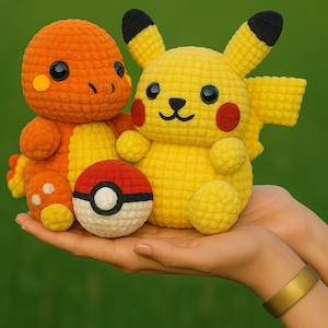 May include: Crocheted Pikachu and Charmander plush toys, along with a Poké Ball, are held in a person's hands. The Pikachu is yellow with red cheeks and black-tipped ears. Charmander is orange. The Poké Ball is red, white, and black.