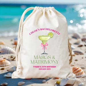 May include: A cream-coloured drawstring bag with a margarita design. The bag features the text "Chloe's Bachelorette," "Margs & Matrimony," and "Tyson's 25th Birthday Chicago 2025." The margarita illustration includes a pink bow and lime wedge.