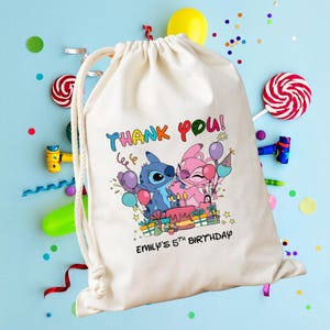 May include: A cream-colored drawstring bag featuring a colorful graphic of Stitch and Angel with balloons and a birthday cake. The text "THANK YOU!" and "EMILY'S 5TH BIRTHDAY" are printed on the bag. Party decorations are scattered around the bag.
