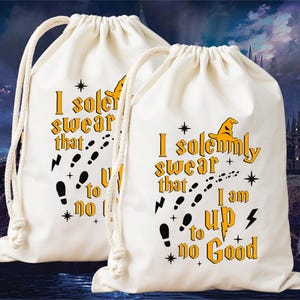 May include: Two off-white drawstring bags with the text "I solemnly swear that I am up to no good" in yellow and black. The bags feature a lightning bolt, footprints, and a wizard hat graphic. The bags have white drawstrings.