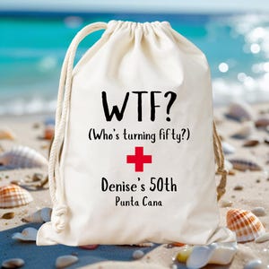 May include: A cream-colored drawstring bag with the text "WTF? (Who's turning fifty?) + Denise's 50th Punta Cana" in black and red. The bag is on a sandy beach with seashells and the ocean in the background.