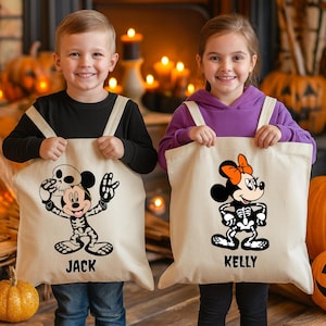 Può includere: Due bambini che tengono borse tote beige con disegni di scheletri di Topolino e Minnie Mouse a tema Halloween. La borsa di Topolino dice "JACK" e la borsa di Minnie dice "KELLY". Ci sono zucche e candele sullo sfondo.